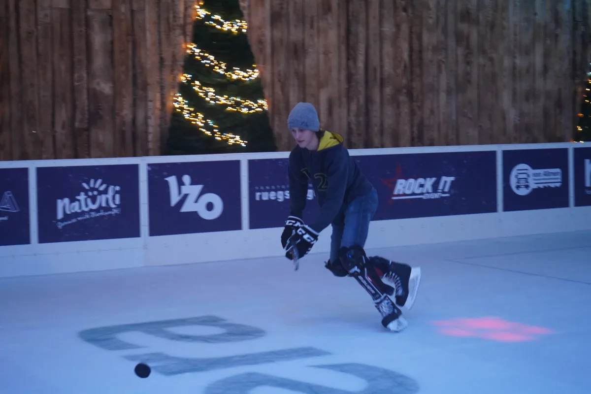 Ein Junge auf dem Eisfeld, er spielt Eishockey